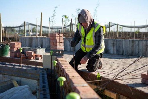 Workman constructing the glasshouse foundations