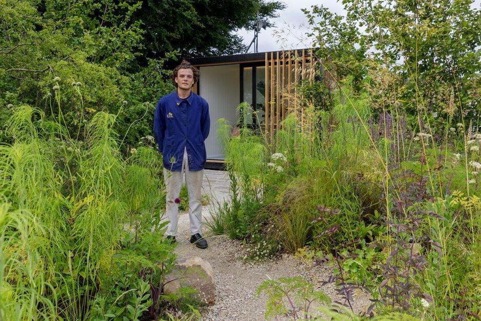 Young designer, Will Scholey, poses with his Working From Home Garden